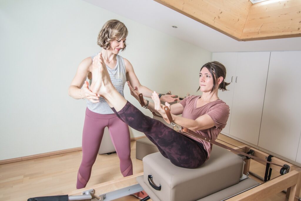 Frau trainiert auf dem Reformer